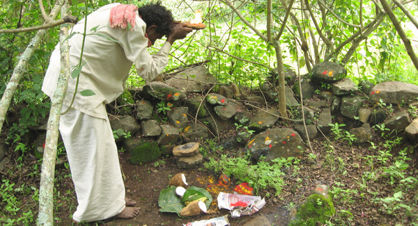 A Soliga paying his obeisance at Devaru sacred natural site in Biligiri Rangaswamy Temple Wildlife Sanctuary, Karnataka, India. After the declaration of the BRTWS in 1974, new rules have made traditional Soliga practices harder and harder, for example by restricting access to their sacred natural sites. Following a ruling by the country’s Supreme Court in 2006, a near-complete ban was imposed upon the collection of NTFPs within sanctuaries and natural parks. In a response to this, the Soliga GPS’ed and mapped their sacred and cultural sites in the forests of the Biligiri Rangaswamy Temple Wildlife Sanctuary. The topographic sheets with sacred natural sites on it were used to help locate the clan boundaries followed by subsequent visits to ascertain the boundaries of the yelles or sacred natural sites. (Source: Nitin, D Rai.)